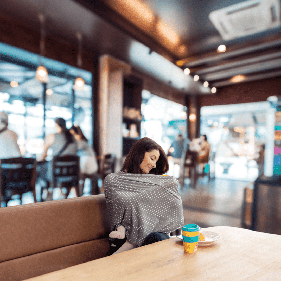 Mum wearing a nursing cover in a cafe