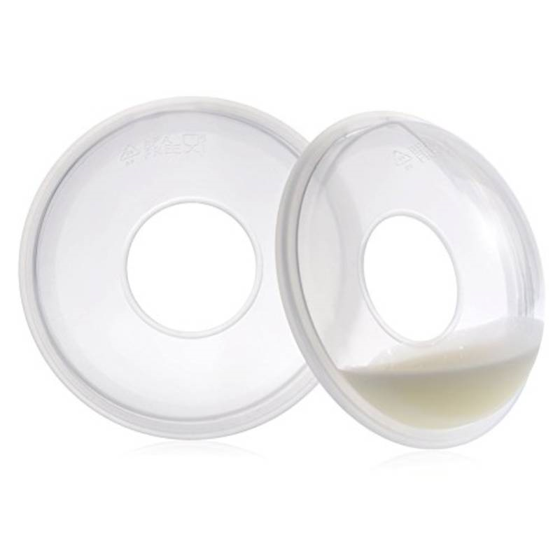 Milk collection cups to collect excess leaking breast milk in a cup by placing on your breast, 2 are shown with milk.