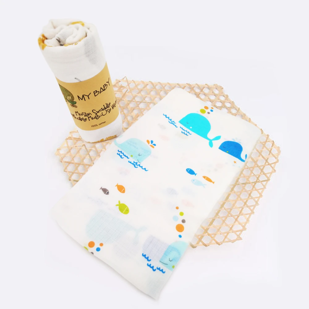 Swaddle Muslin for a baby in a pattern of blue whales, made from cotton.
